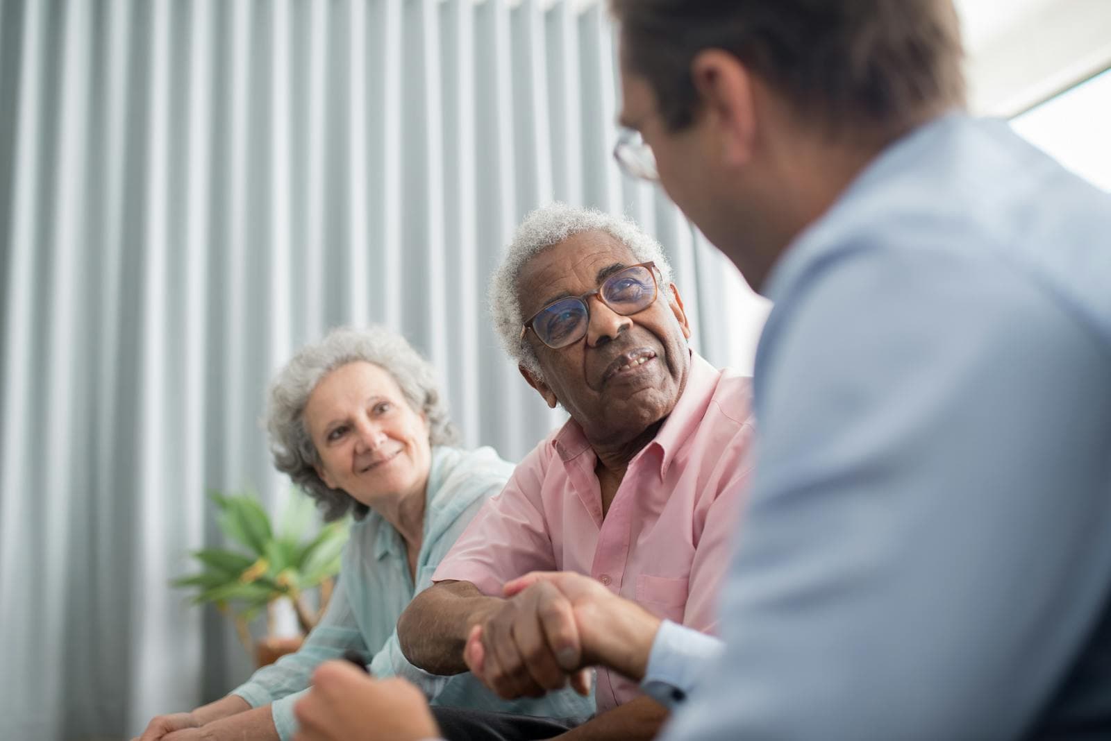 An elderly man consults with a professional advisor at home — the right way to interview a senior care agency.